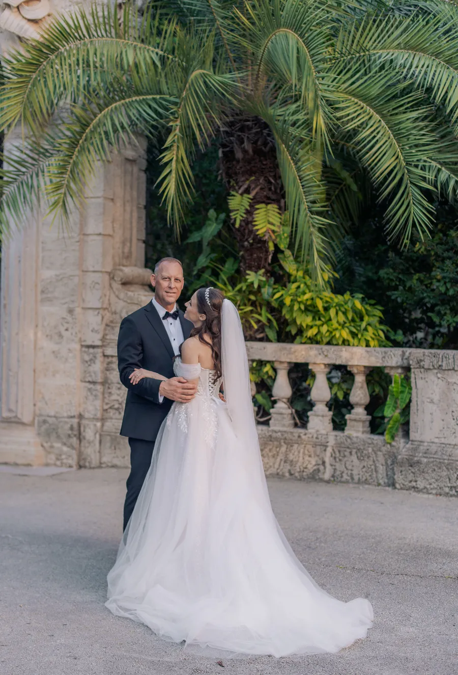 Bride and groom embracing in a tropical estate garden
