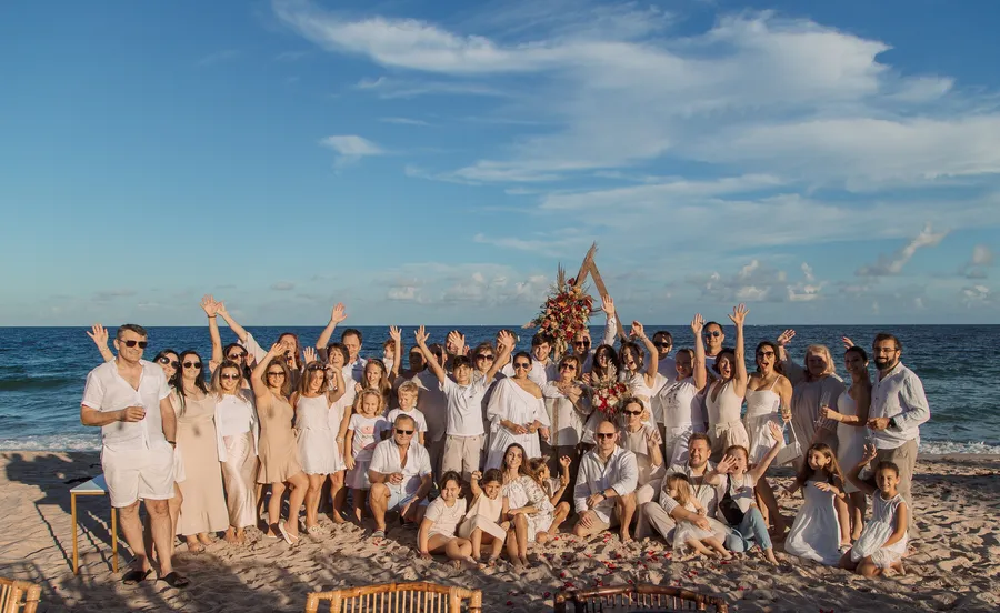Newlyweds posing beneath a rustic beach ceremony arch — Roman and Victoria wedding