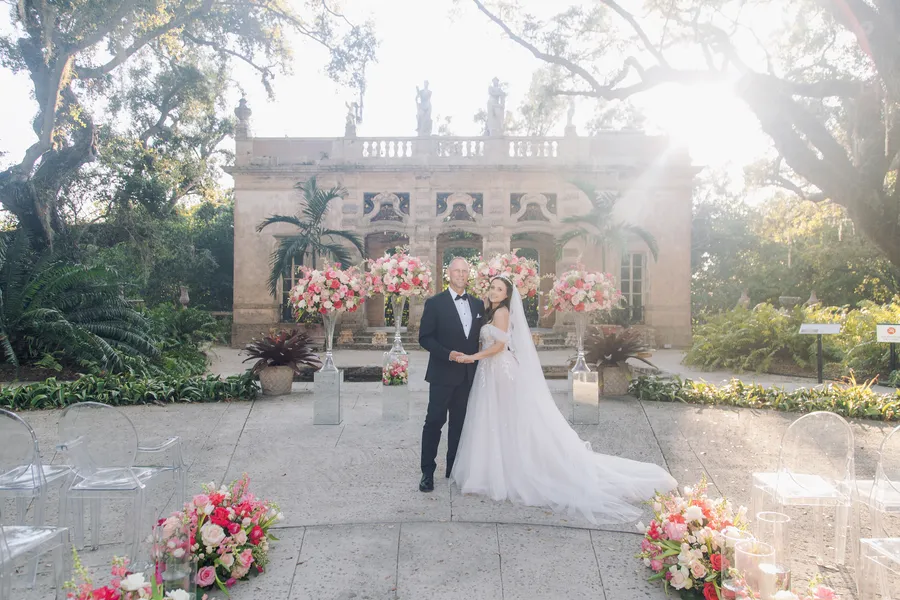 Bride and groom beneath abundant pink ceremony flowers — Steven and Iryna wedding